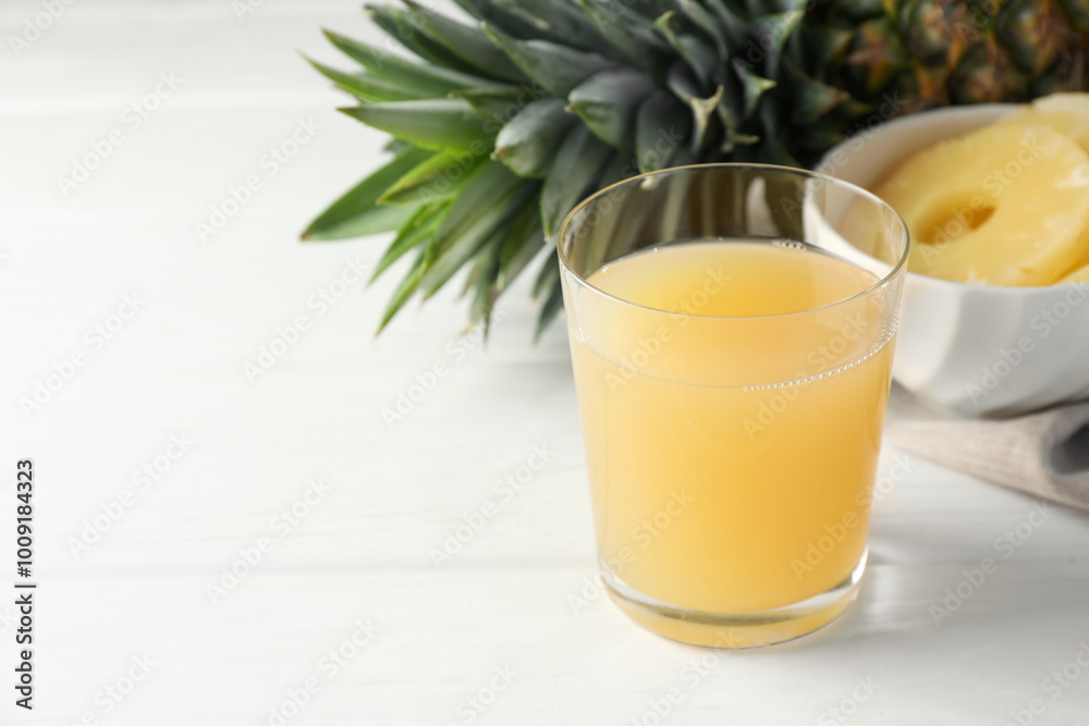 Tasty pineapple juice in glass and fresh fruit on white wooden table, closeup. Space for text Tasty pineapple juice in glass and fresh fruit on white wooden table, closeup. Space for text