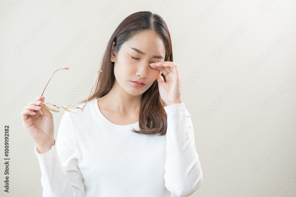 Eye problem concept, fatigue asian young woman tired eyes irritated rubbing, massage eye dry relief vision pain after work, eye strain, hand holding glasses, suffer bad blurry isolated on background. Eye problem concept, fatigue asian young woman tired eyes irritated rubbing, massage eye dry relief vision pain after work, eye strain, hand holding glasses, suffer bad blurry isolated on background.