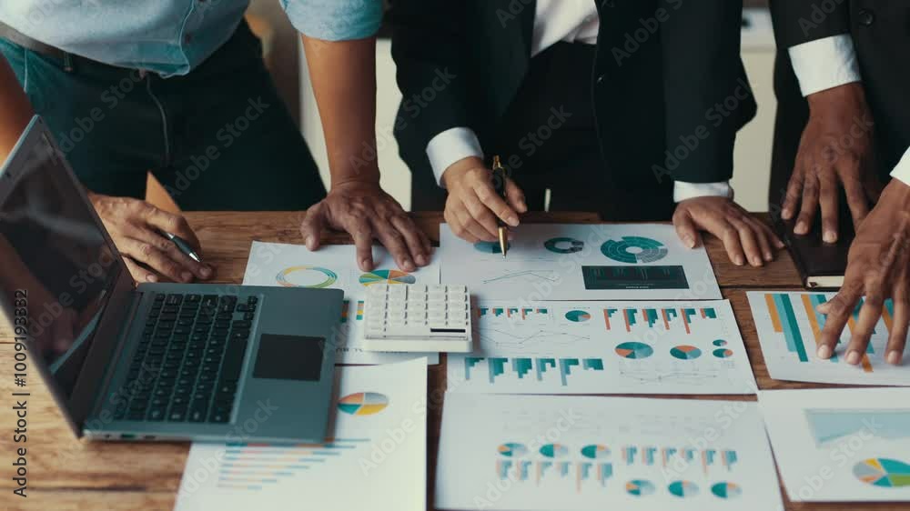 Business team collaborating on financial data analysis at a wooden table, showcasing teamwork and strategic planning
