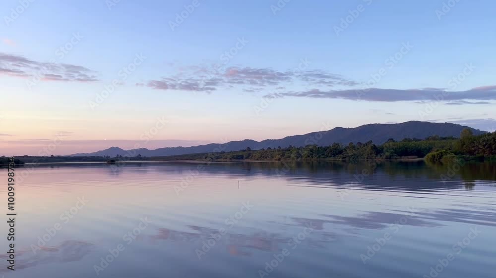 a calm lake at dawn, reflecting the soft hues of the sky on its still surface, silhouette of distant hills and trees frames the horizon, water gently mirroring the serene landscape, sky transitions a calm lake at dawn, reflecting the soft hues of the sky on its still surface, silhouette of distant hills and trees frames the horizon, water gently mirroring the serene landscape, sky transitions