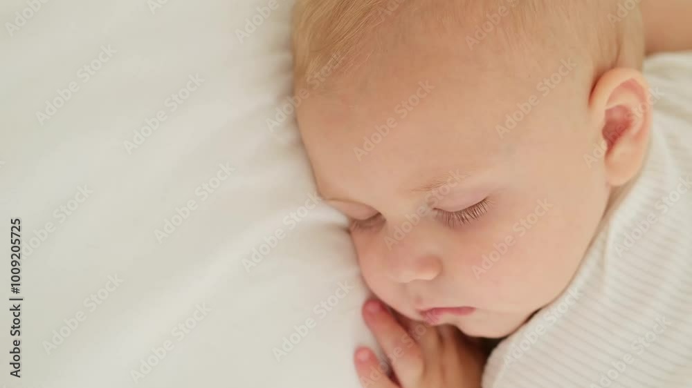 a newborn baby sleeps sweetly on his tummy, a place for text, a baby sleeps on a white bed with a pen under his cheek, a healthy baby's sleep, a close-up portrait a newborn baby sleeps sweetly on his tummy, a place for text, a baby sleeps on a white bed with a pen under his cheek, a healthy baby's sleep, a close-up portrait