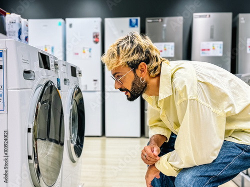 Man inspecting washing machine in appliance store...