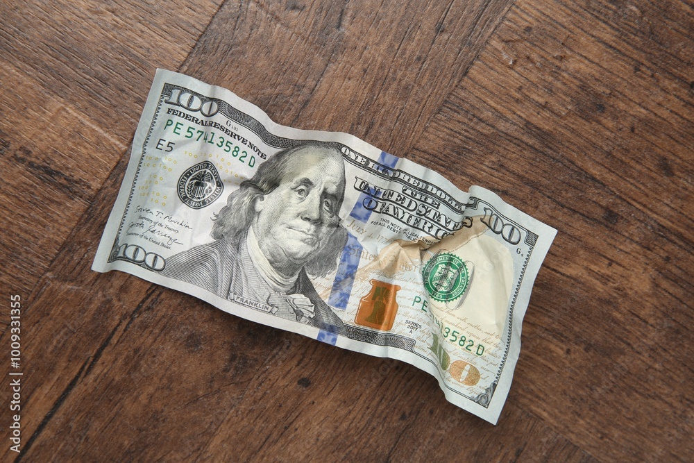 One crumpled dollar banknote on wooden table, top view One crumpled dollar banknote on wooden table, top view