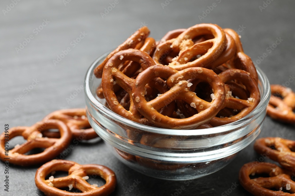 Delicious pretzel crackers on black table, closeup