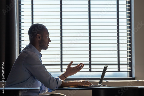 Businessman dressed in shirt having video call on computer in office