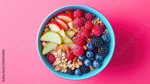 A bowl of granola with fresh fruit, including apples, raspberries, blueberries, and blackberries.