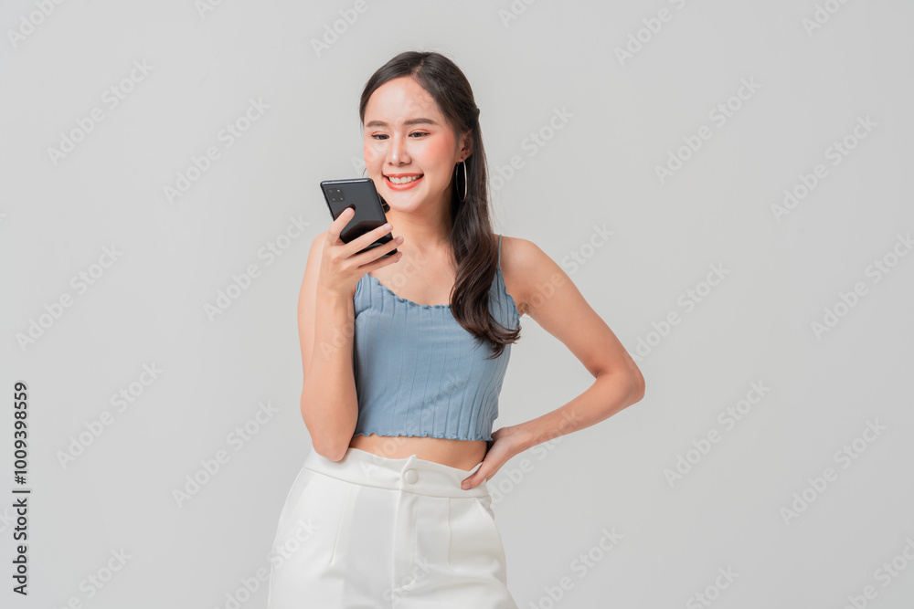 A young woman smiles while using her smartphone, showcasing casual and cheerful vibe. Her stylish outfit complements modern setting A young woman smiles while using her smartphone, showcasing casual and cheerful vibe. Her stylish outfit complements modern setting