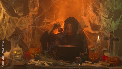 Foto A witch in black clothing pulls a poisoned apple from a cauldron in a scary kitchen with pumpkins and human bones