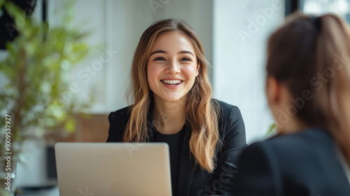 Free Download A woman is sitting at a table with a laptop in front of her - GFXLoad