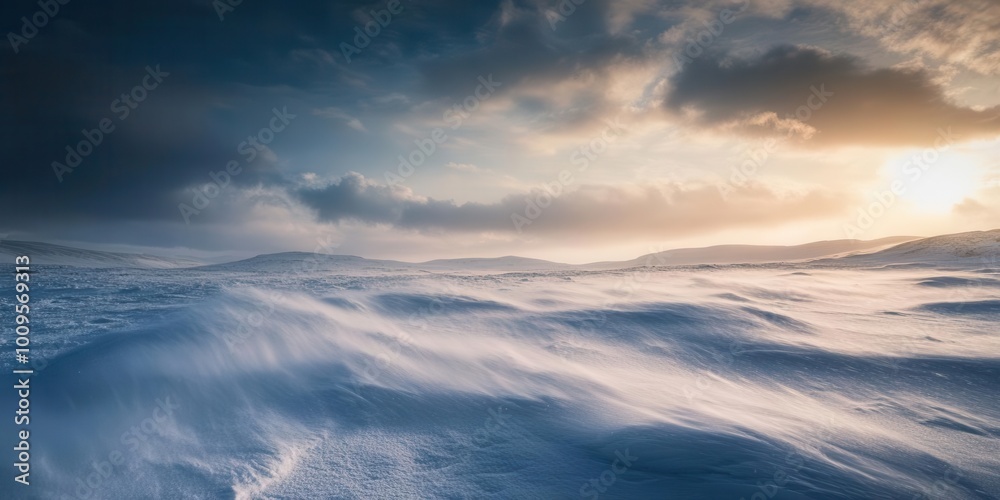 Obraz premium A serene winter landscape with gentle snow drifts and a dramatic sky at sunset.