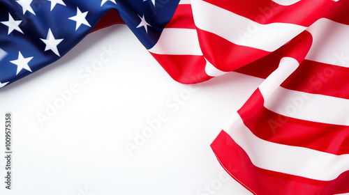 A close-up view of the American flag, featuring the stars and stripes in vibrant colors. The fabric appears to be flowing, creating a dynamic and patriotic feel. The background is plain white