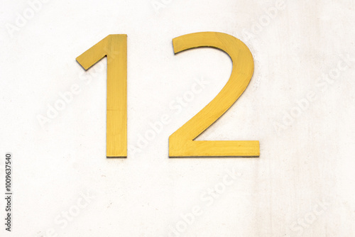 Number twelve in gold color on white background