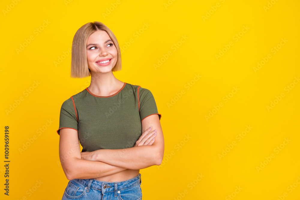 Obraz premium Photo of positive girl with bob hair dressed khaki t-shirt arms folded look at promo empty space isolated on yellow color background