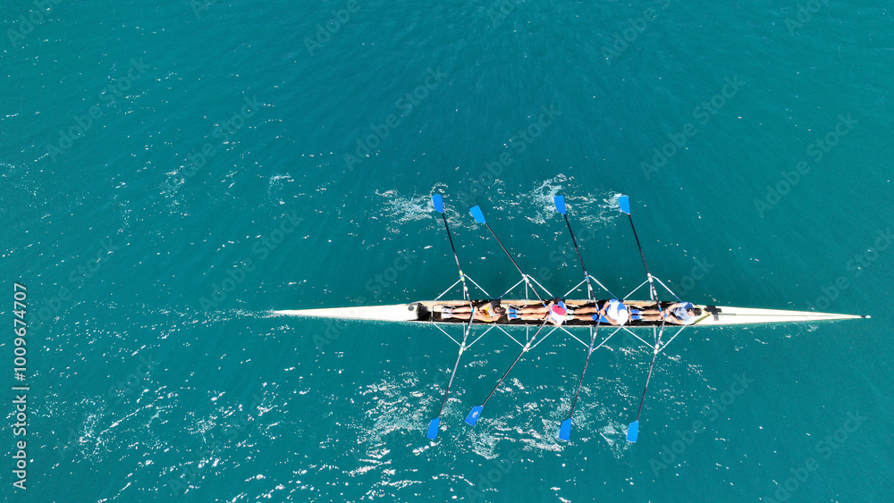 Aerial drone photo of sport canoe operated by team of young trained athletes in deep emerald sea