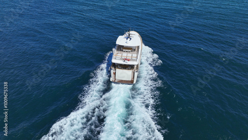 Obraz na płótnie Aerial drone photo of latest technology small yacht cruising near famous beach of Ornos, Mykonos island, Cyclades, Aegean sea, Greece w salonie