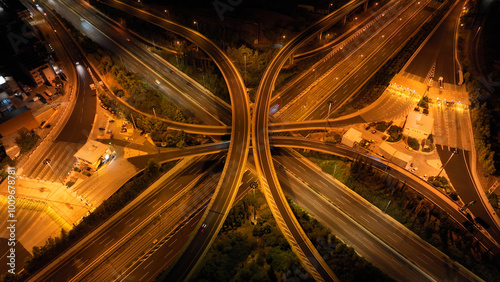 Aerial drone long exposure night shot of highway multilevel junction highway with light traffic leaving car headlights white and red trails