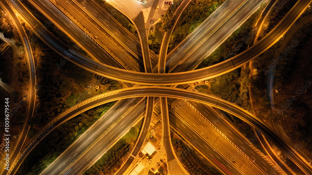 Aerial drone long exposure night shot of highway multilevel junction highway with light traffic leaving car headlights white and red trails