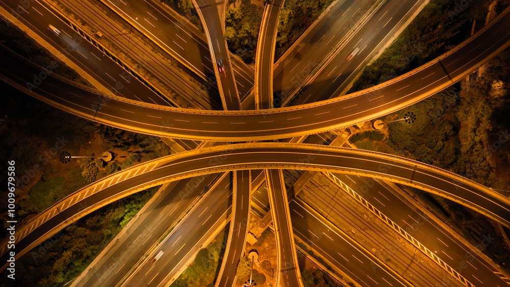 Aerial drone long exposure night shot of highway multilevel junction highway with light traffic leaving car headlights white and red trails