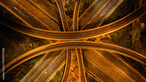 Obraz na płótnie Aerial drone long exposure night shot of highway multilevel junction highway with light traffic leaving car headlights white and red trails w salonie