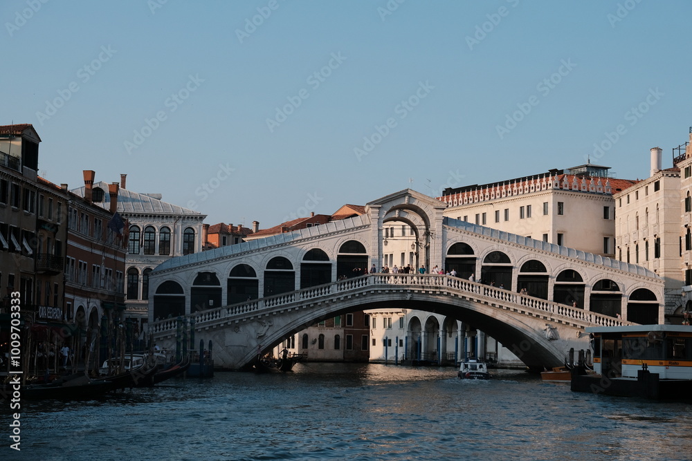 A bridge spans a large body of water, with impressive buildings behind A bridge spans a large body of water, with impressive buildings behind