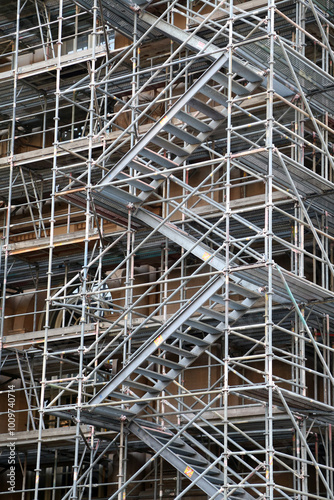 Wallpaper Mural Sturdy steel staircase winds through a complex grid of scaffolding, illustrating the active construction process and the intricate support systems in place for building projects Torontodigital.ca