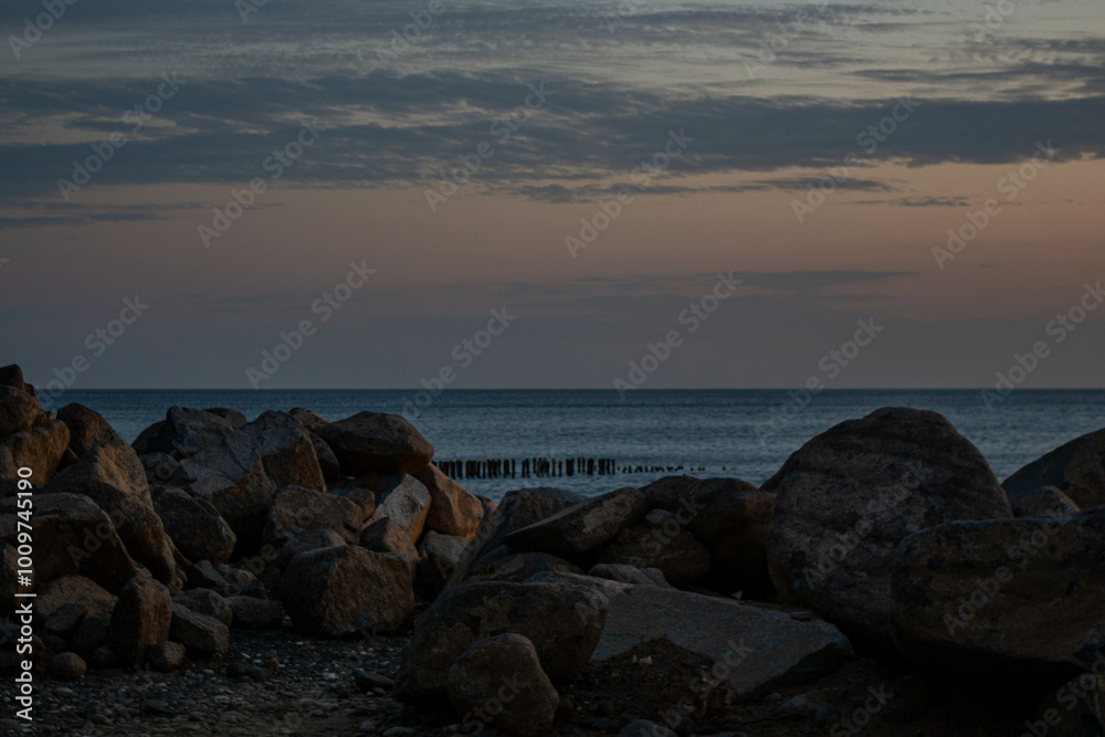 Sunset on the beach. Sunset on a cloudy sky. Large stones on the beach. Sunset on the beach. Sunset on a cloudy sky. Large stones on the beach.