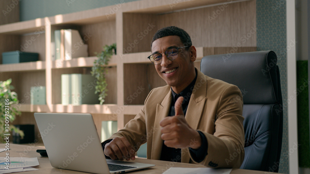 African American 30s millennial business man happy businessman smiling entrepreneur office manager working laptop typing on computer looking camera smile show thumb up gesture aprove recommend like African American 30s millennial business man happy businessman smiling entrepreneur office manager working laptop typing on computer looking camera smile show thumb up gesture aprove recommend like