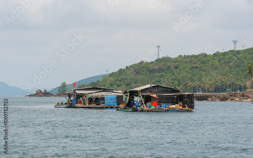 Vietnamese houses on the water, fish farms and fishing boats on the background of tropical islands photo