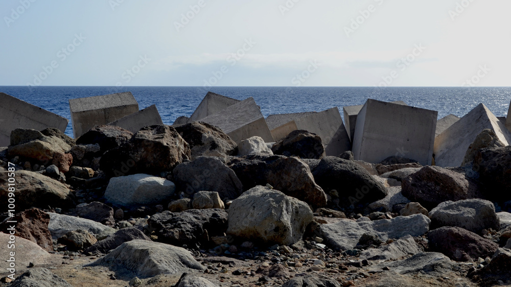 Breakwater with concrete blocks and stones for protection from strong ocean waves Breakwater with concrete blocks and stones for protection from strong ocean waves
