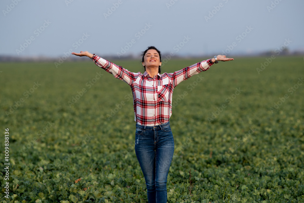 Satisfied woman with raised hands in green field Satisfied woman with raised hands in green field