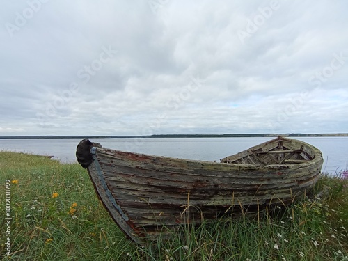 boat on the beach. An old wooden fishing boat on the seashore. An abandoned boat