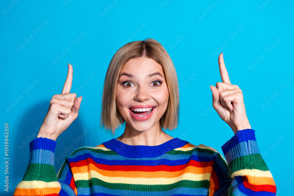 Photo of nice young woman direct fingers up empty space wear striped sweater isolated on blue color background