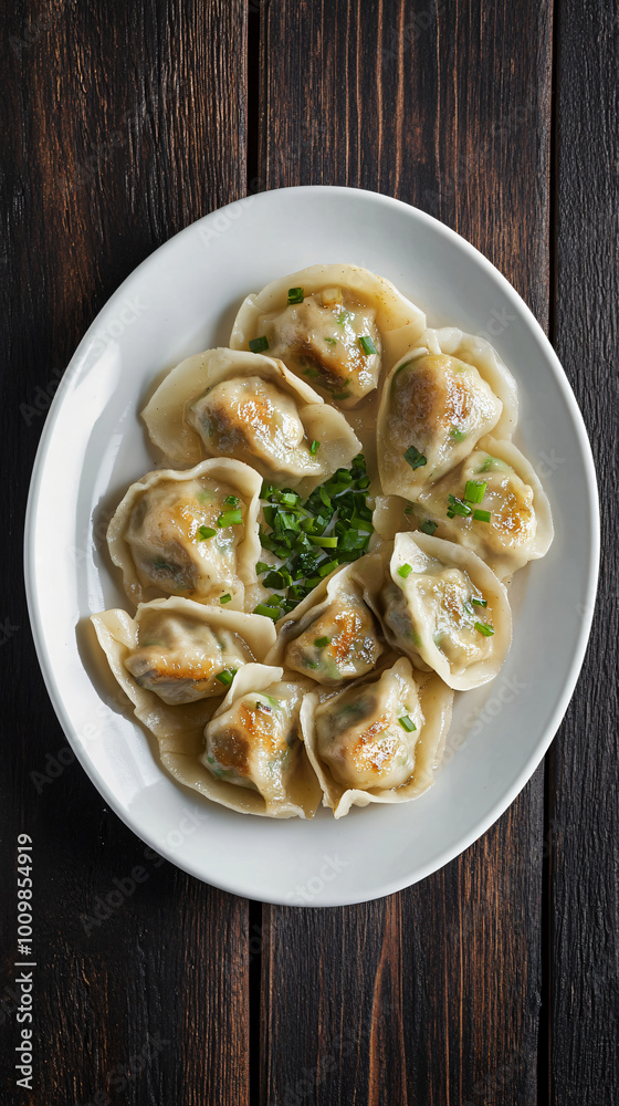 Delicious steamed dumplings with green onion dressing served on a white plate standing on a dark wooden table Delicious steamed dumplings with green onion dressing served on a white plate standing on a dark wooden table