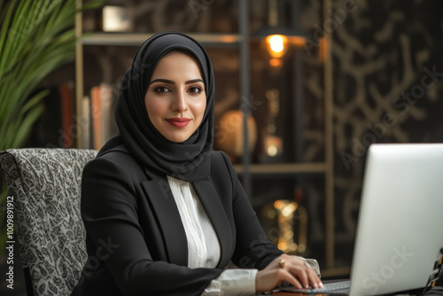 An Arab female lawyer in her 30s participating in a video conference, dressed in business attire, with a contemporary office environment featuring warm lighting and legal artifacts around her.