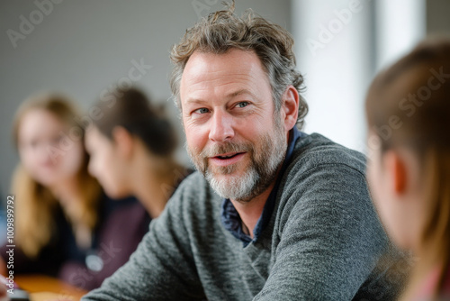 A middle-aged Caucasian man leading a workshop discussion, engaging participants from various backgrounds with thought-provoking questions. The atmosphere is dynamic and collaborative.