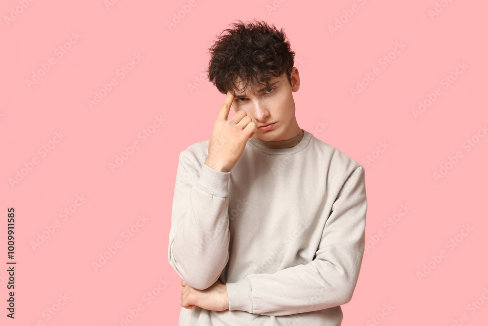 Handsome young man in stylish sweatshirt on pink background