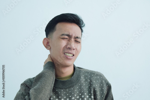 Close up asian young man touching neck in neckache or pain isolated on white background photo