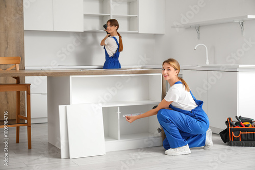 Two women install kitchen c...