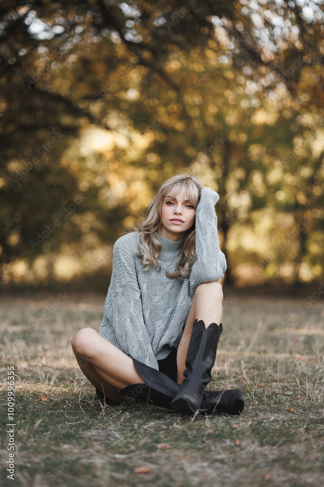 Fashion portrait of a charming young girl walking in an autumn park and enjoying the warm autumn. Fashion portrait of a charming young girl walking in an autumn park and enjoying the warm autumn.