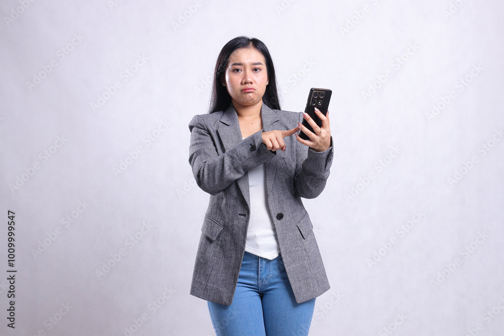 beautiful mature office lady asia pouting to camera while touching, holding cellphone wearing grey suit isolated on white background. for technology, lifestyle, shopping, transaction content beautiful mature office lady asia pouting to camera while touching, holding cellphone wearing grey suit isolated on white background. for technology, lifestyle, shopping, transaction content