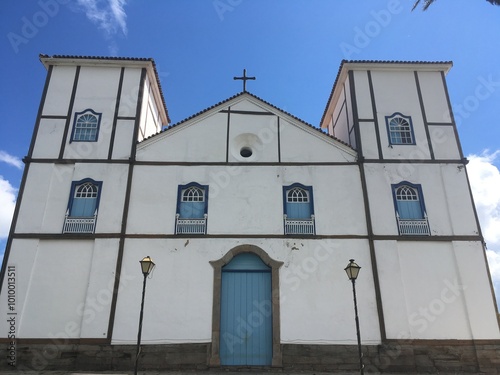 Paisagem histórica de Pirenópolis, Goiás, Brasil, com uma igreja alta contra um céu azul claro. A foto captura o charme e a arquitetura colonial da cidade. photo