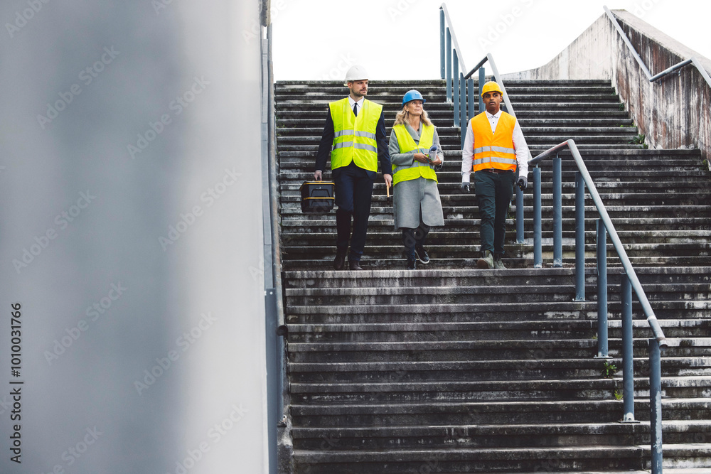 Construction industry and engineering - engineers, architects and contractors on the construction site analyzing the development of the building Construction industry and engineering - engineers, architects and contractors on the construction site analyzing the development of the building