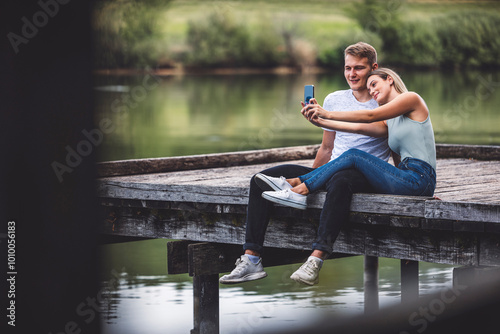 Friends enjoying a day at the lake. Freshly in love couple walking by the lake, hiding from their parents. Holding each other, sharing love.