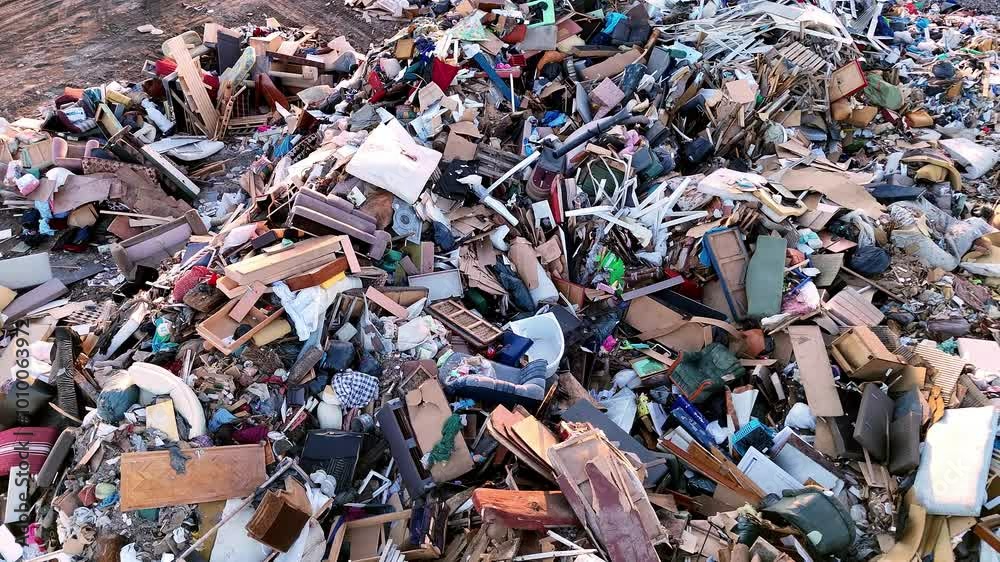 4k aerial view of a large landfill filled with mixed household and construction waste, including furniture, plastic, and other debris. 4k aerial view of a large landfill filled with mixed household and construction waste, including furniture, plastic, and other debris.