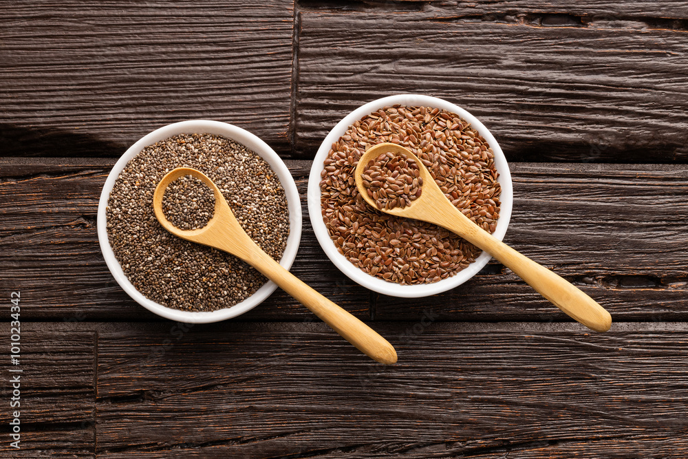 Flax and chia seeds in bowls and spoons - Salvia hispanica and Linum usitatissimum. Flax and chia seeds in bowls and spoons - Salvia hispanica and Linum usitatissimum.
