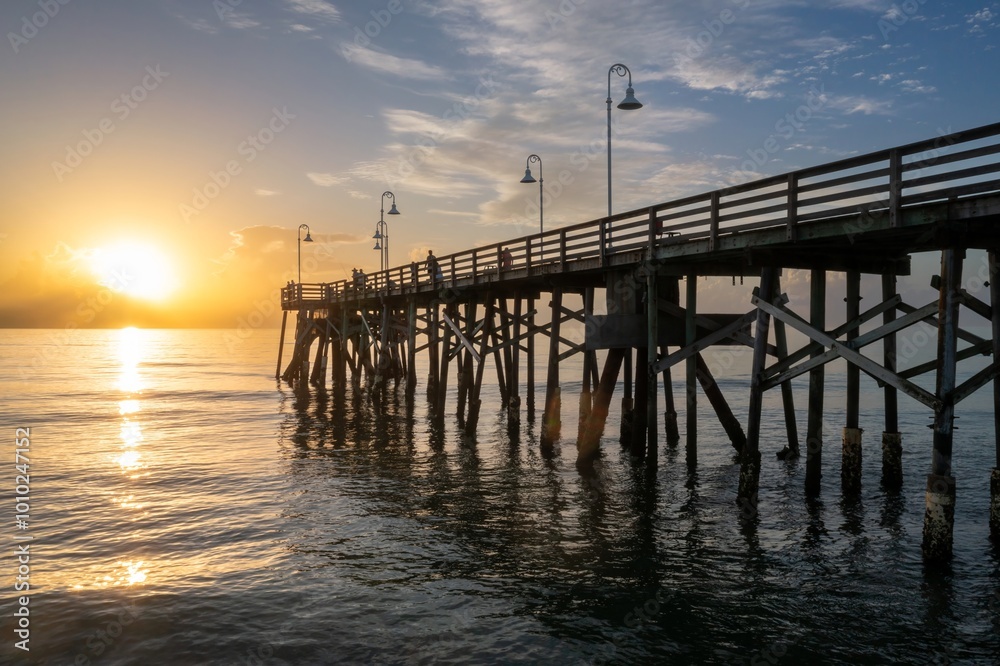 People fishing off the Daytona Beach Main Street Pier and calm ocean at sunrise, Daytona Beach, Florida, United States. People fishing off the Daytona Beach Main Street Pier and calm ocean at sunrise, Daytona Beach, Florida, United States.