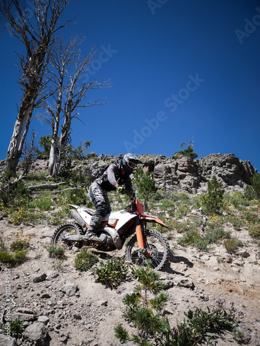 Dirt biker on rocky trail in Madison Mountain Range in Gallatin National Forest near Big Sky Montana  photo