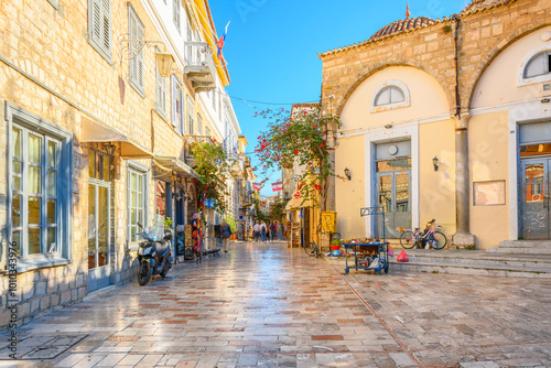 Fototapeta Naklejka Na Ścianę i Meble -  A colorful narrow street of shops, boutiques and cafes in the picturesque old town of Nafplio, Greece, a seaside town in the Southern Peloponnese district.
