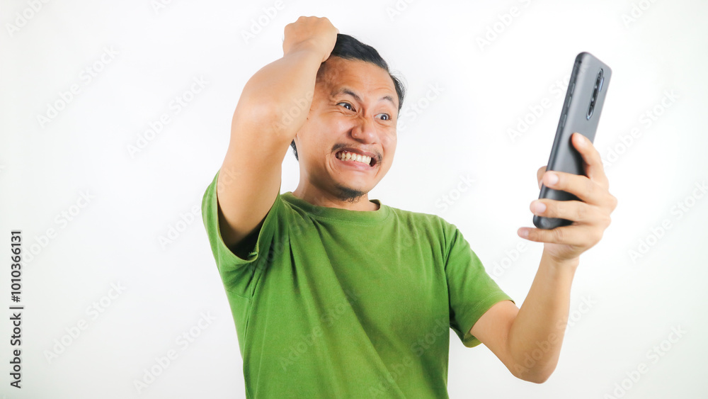Shocked young Asian man looking at mobile phone screen, reacting to online news. Advertising concept. Shocked young Asian man looking at mobile phone screen, reacting to online news. Advertising concept.