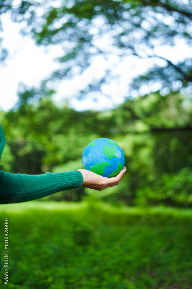 An Asian woman holds a globe in a green forest,symbolizing the importance of preserving nature.emphasizes balance between humans, natural resources,sustainable environmental development protect An Asian woman holds a globe in a green forest,symbolizing the importance of preserving nature.emphasizes balance between humans, natural resources,sustainable environmental development protect